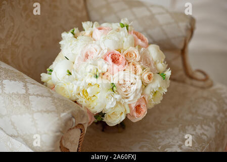 Belle fleur mauve rose beige rose roses, orchidées, chrysanthèmes et hortensias et eustomasbouquet mixte blanc sur le canapé marron. Banque D'Images