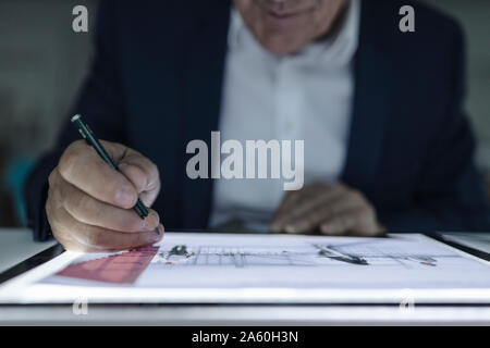 Close-up of senior businessman dessin sur tablette brillant Banque D'Images