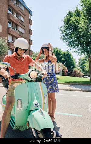 Jeune couple standing at vintage motor scooter Banque D'Images
