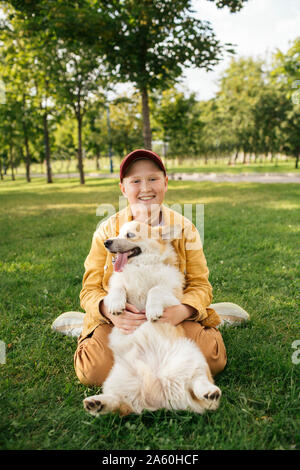 Garçon avec Welsh Corgi Pembroke dans un parc Banque D'Images