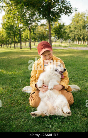 Garçon avec Welsh Corgi Pembroke dans un parc Banque D'Images