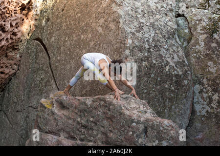 Young Asian woman practicing yoga on a rock Banque D'Images