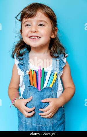 Portrait of cute little girl avec les stylos à bille de couleur sur sa poche Banque D'Images