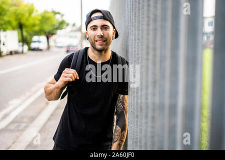 Portrait of a young smiling man with baseball cap dans la ville Banque D'Images