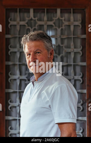 Portrait of a senior man en face d'une porte en fer Banque D'Images