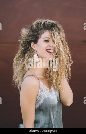 Portrait de jeune femme en riant avec frisettes teints en blond Banque D'Images