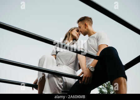 Jeune couple qui s'embrassent sur un mur d'escalade Banque D'Images