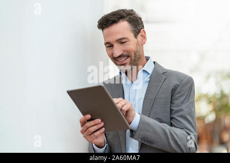 Smiling businessman using tablet dans la ville Banque D'Images