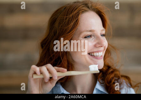 Portrait de femme rousse riant avec une brosse à dents Banque D'Images