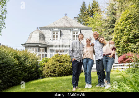 Happy senior couple avec enfants adultes debout dans leur maison de jardin Banque D'Images