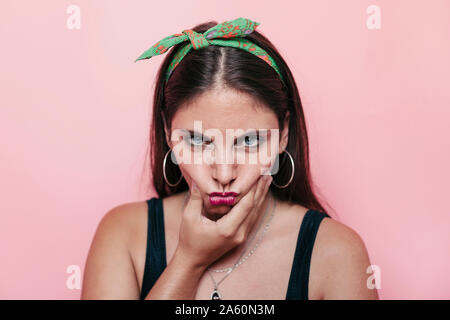 Jeune femme aux yeux bleus regardant la caméra et faire un visage en colère stupide Banque D'Images