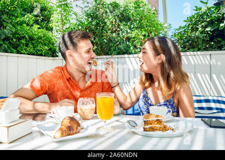 Cheerful young couple having breakfast Banque D'Images