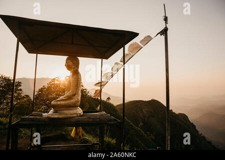 Statue de Bouddha au sommet de la colline à Little Adam's Peak contre le ciel au coucher du soleil, le Sri Lanka Banque D'Images