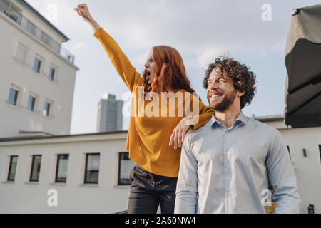 Femme avec collègue sur la terrasse du toit clenching fist Banque D'Images