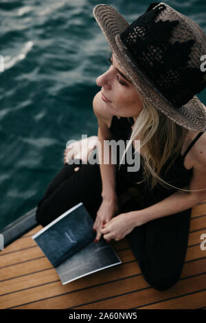 Femme avec un livre sur un bateau Banque D'Images