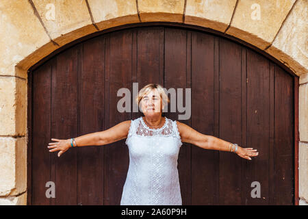 Portrait of a senior woman devant une porte en bois Banque D'Images