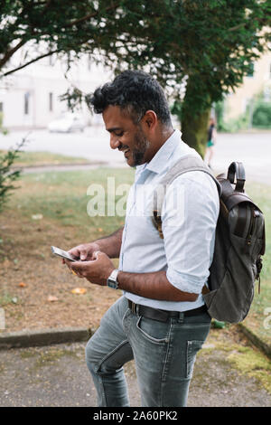 Happy businessman using smartphone dans la ville Banque D'Images