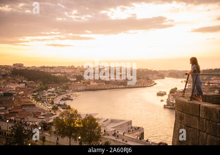 Femme regardant vue panoramique de Porto au coucher du soleil, Portugal Banque D'Images