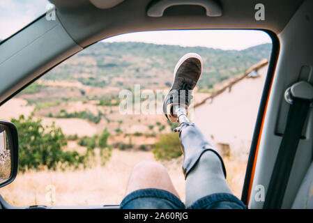 Les jambes de jeune homme prothétique pend hors de la fenêtre de camping-car Banque D'Images