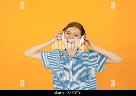 Portrait of happy woman listening to music avec fond orange Banque D'Images