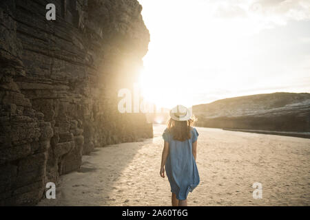 Femme marche sur la plage des Cathédrales de pierres, vue arrière, Galice, Espagne Banque D'Images