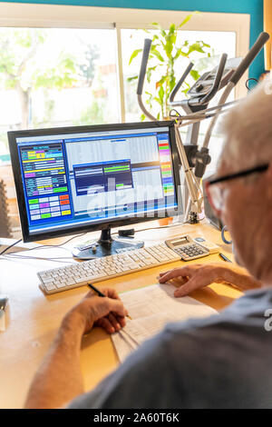 Senior man working in office, à l'aide d'ordinateur Banque D'Images