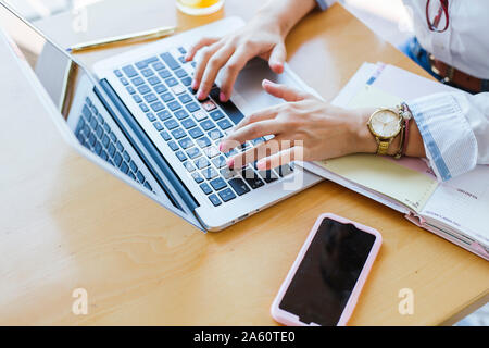 Mains de young woman using laptop on table Banque D'Images