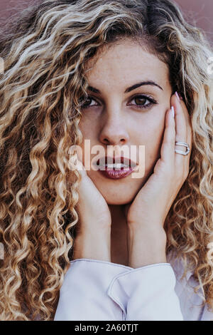 Portrait de jeune femme avec des frisettes teints en blond Banque D'Images