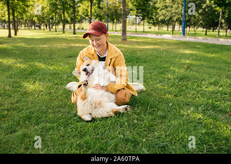 Garçon avec Welsh Corgi Pembroke dans un parc Banque D'Images