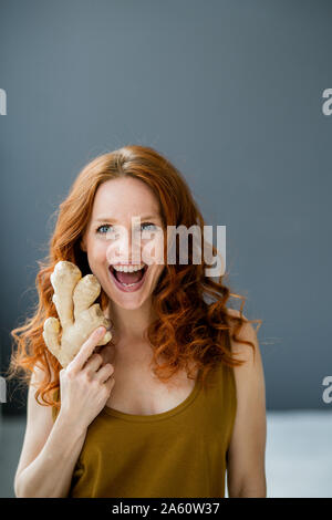 Portrait de femme rousse excité avec la racine de gingembre Banque D'Images