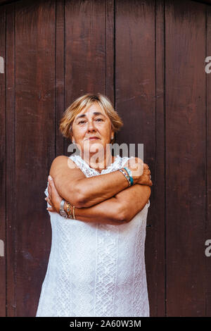 Portrait of a senior woman devant une porte en bois Banque D'Images