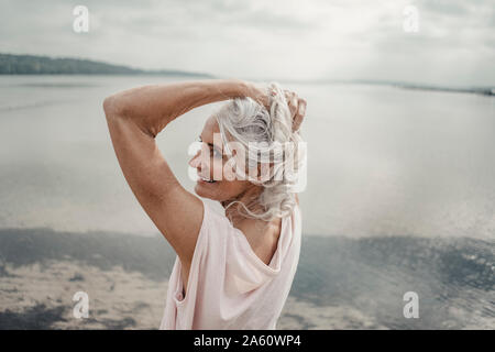 Les cheveux blancs senior woman posing by the sea Banque D'Images