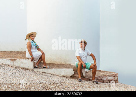 Tourisme Senior couple sitting on steps dans un village, El Roc de Sant Gaieta, Espagne Banque D'Images