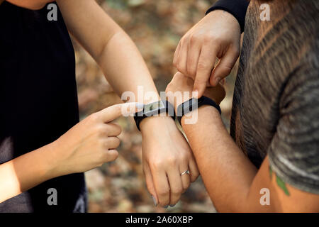 Close-up of couple checking smartwatches sportive Banque D'Images