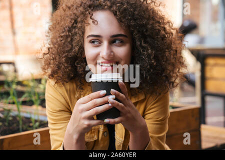 Portrait of smiling woman drinking coffee pour aller à l'extérieur Banque D'Images