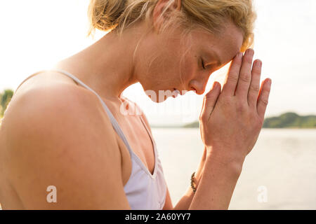 Close-up of young woman with closed eyes à un lac Banque D'Images