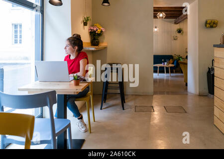 Young woman using laptop in a cafe Banque D'Images