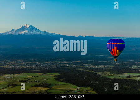 Vue aérienne de l'air chaud ballon flottant sur les terres agricoles et le mont Rainier dans la distance, l'État de Washington, États-Unis d'Amérique, Amérique du Nord Banque D'Images