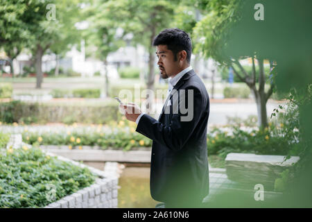 Young businessman with cell phone dans la ville Banque D'Images