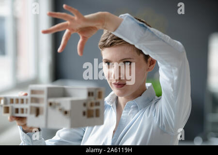 Confident businesswoman holding architectural model in office Banque D'Images