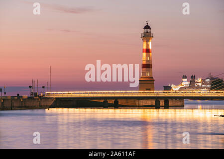 Pont sur la rivière illuminée avec phare en arrière-plan contre ciel à Malmö, Suède Banque D'Images