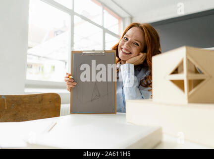 Portrait de femme rousse avec le dessin et modèle architectural dans un loft Banque D'Images