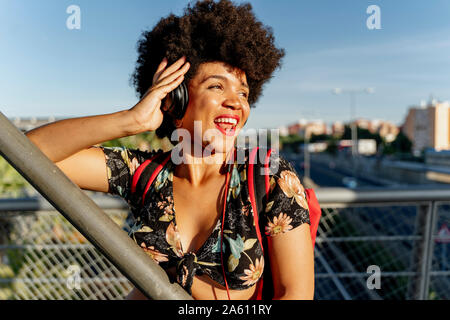 Style de femme avec un casque à l'écoute de la musique, à côté Banque D'Images