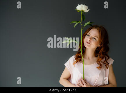Portrait de femme rousse avec pivoine blanche