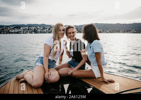 Happy female friends having fun sur un voyage en bateau sur un lac Banque D'Images