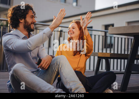 Deux heureux collègues fiving haut sur la terrasse du toit Banque D'Images