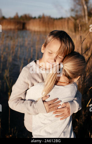 Portrait of boy hugging sa petite sœur dans la nature d'automne Banque D'Images