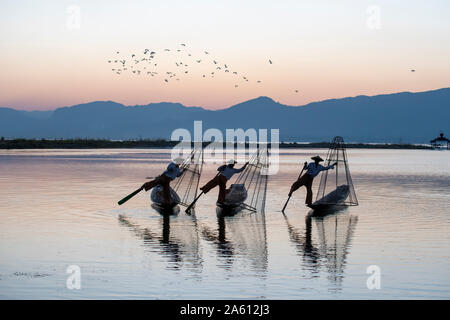 Trois rameurs sur jambe ethnie Intha au Lac Inle, à l'État de Shan, Myanmar (Birmanie), l'Asie Banque D'Images