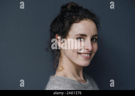 Portrait de jeune femme à l'arrière-plan gris