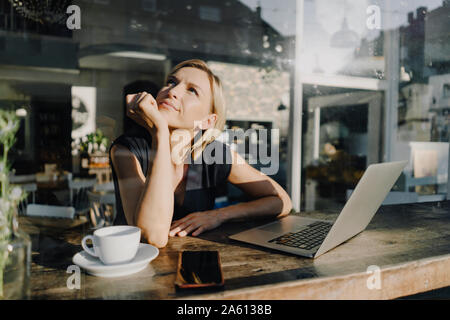 Blonde woman using laptop in a Coffee shop Banque D'Images